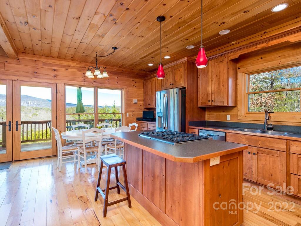 206 Legend Dr Mill Spring, Unit 8 Mill Spring, NC 28756 - Photo 22 of 47 a kitchen with stainless steel appliances granite countertop a stove top oven a dining table and chairs with wooden floor
