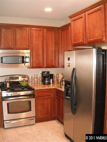 13755 Seabiscuit Drive Reno, NV 89521 - Photo 3 of 12 a kitchen with stainless steel appliances granite countertop a stove a refrigerator and a microwave