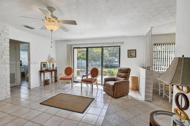 a living room with furniture a flat screen tv and a floor to ceiling window
