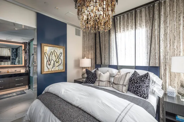 a bedroom with a large bed and a chandelier