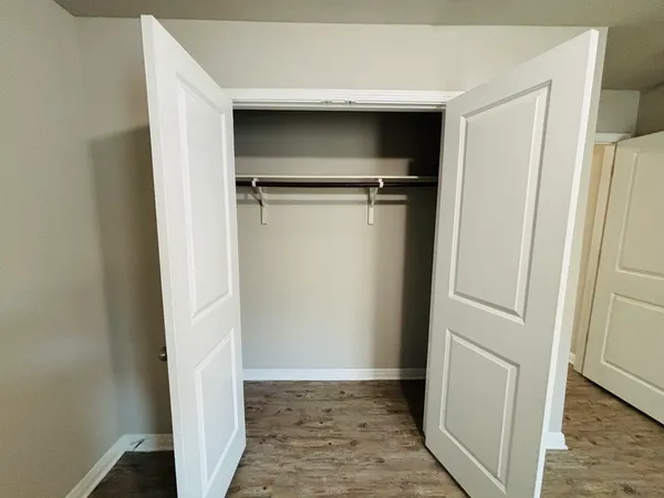 a view of a room with wooden floor and a hallway