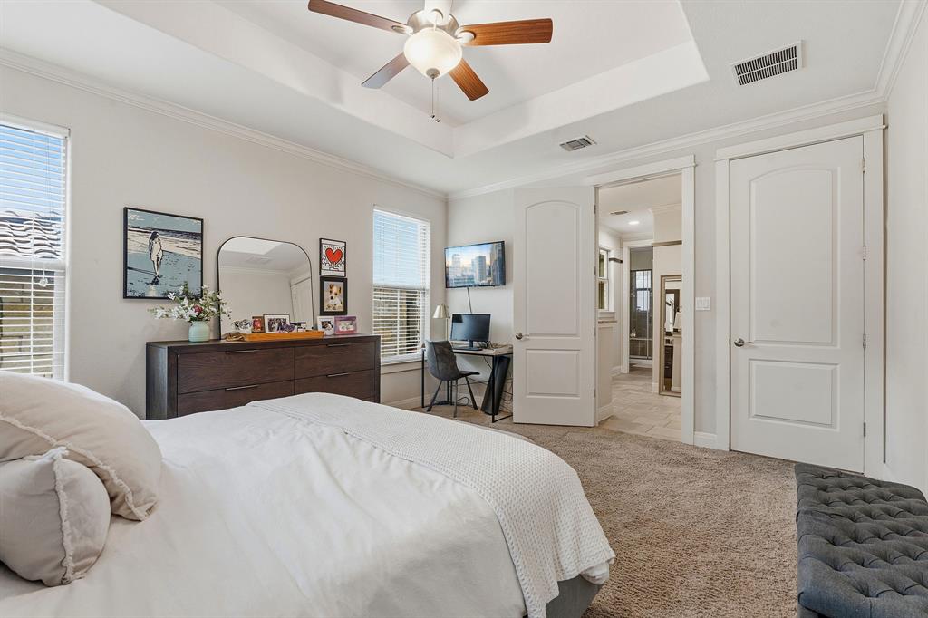 15317 Falconhead Grove Loop Austin, TX 78738 - Photo 14 of 29 A tranquil primary bedroom with a tray ceiling and a ceiling fan offers a private escape.