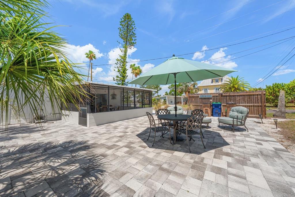 127 11th Avenue Indian Rocks Beach, FL 33785 - Photo 29 of 63 a view of a patio with a table and chairs under an umbrella