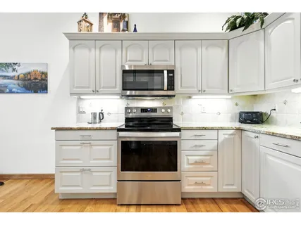 a kitchen with granite countertop white cabinets and white appliances