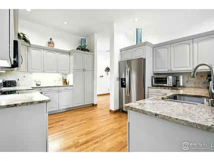 a kitchen with stainless steel appliances kitchen island granite countertop a refrigerator and a stove top oven