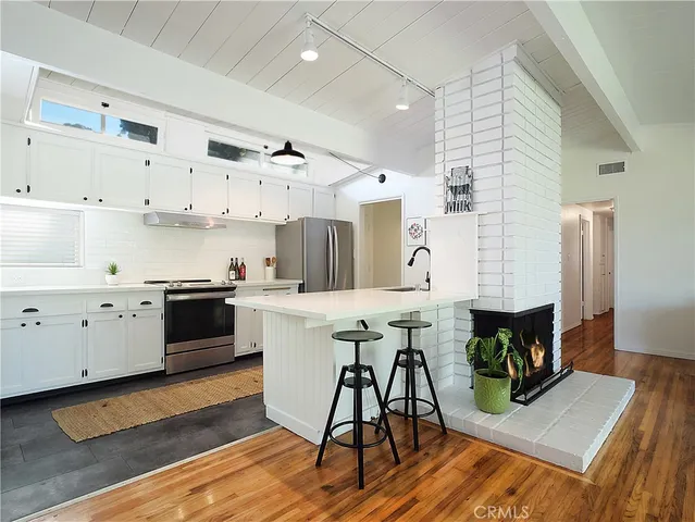 a kitchen with a table chairs microwave and cabinets