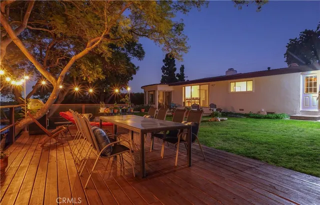 a view of a patio with table and chairs with wooden floor and fence