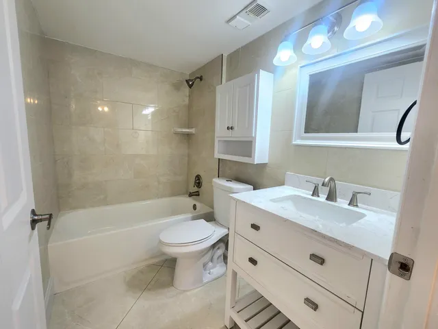 a bathroom with a sink toilet a mirror and shower