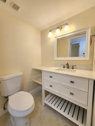 a bathroom with a toilet a sink and mirror