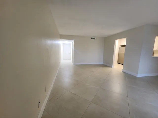 an empty room with a ceiling fan and a window