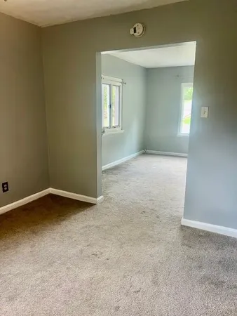 an empty room with a window and a ceiling fan