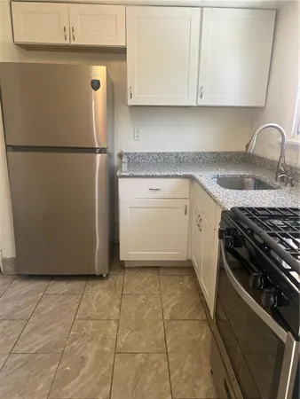 a kitchen with a stove a refrigerator and cabinets