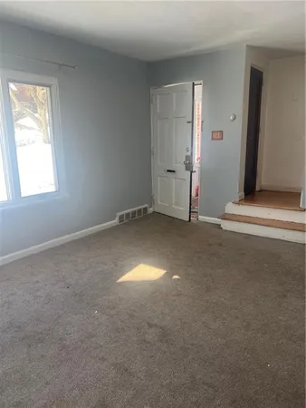 an empty room with a window and stairs