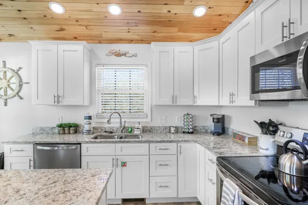 a kitchen with stainless steel appliances granite countertop a sink stove and cabinets