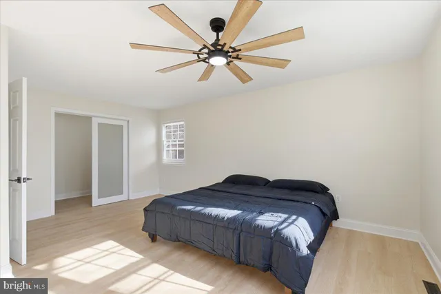 a bedroom with a bed and a ceiling fan