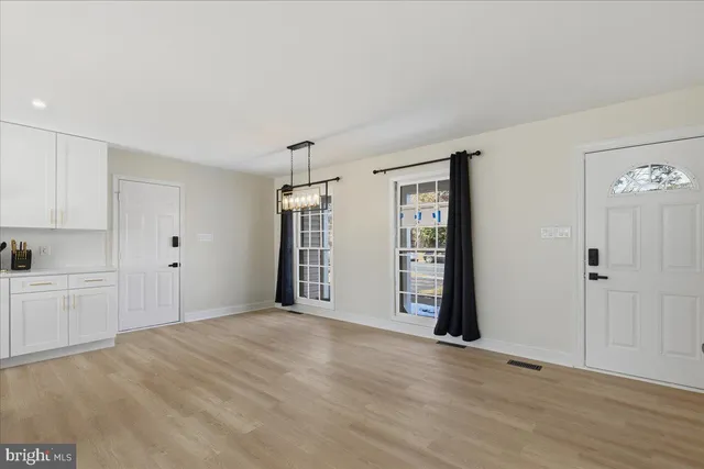 a view of an empty room with window and cabinet