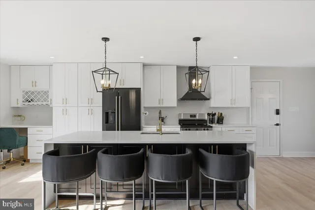 a kitchen with a dining table chairs cabinets and stainless steel appliances