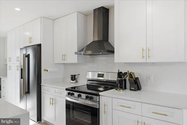 a kitchen with stainless steel appliances granite countertop white cabinets and a stove