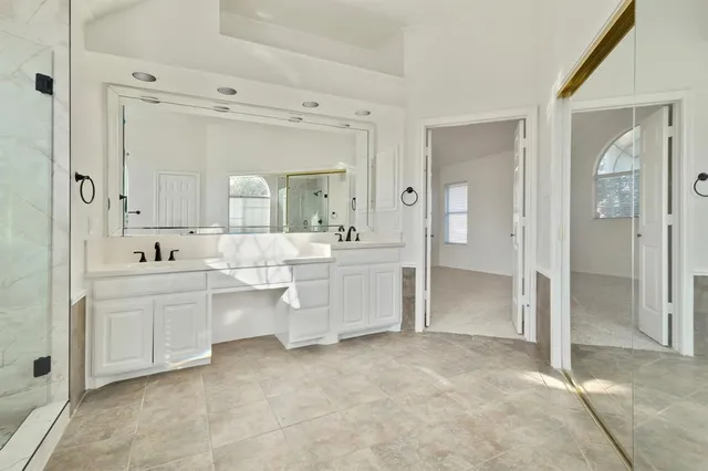 a bathroom with a double vanity sink mirror and bathtub