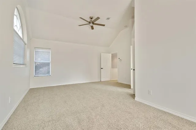 an empty room with windows and fan