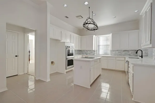 a kitchen with a refrigerator and white cabinets