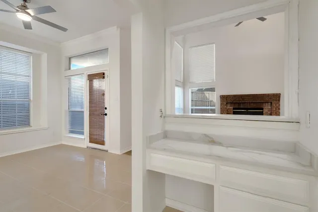 a living room with a fireplace and a ceiling fan