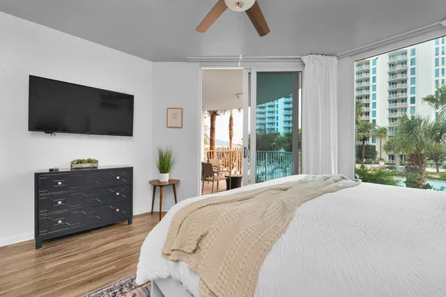 a spacious bedroom with a bed and a flat screen tv