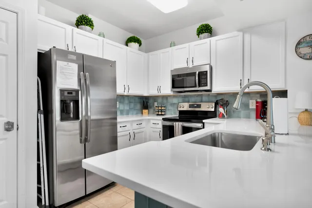 a kitchen with stainless steel appliances a refrigerator sink and microwave