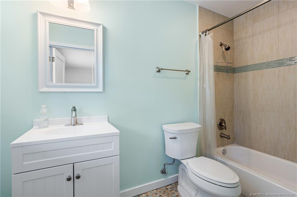 10 South Sewalls Point Road Stuart, FL 34996 - Photo 45 of 79 a bathroom with a toilet sink vanity shower and mirror