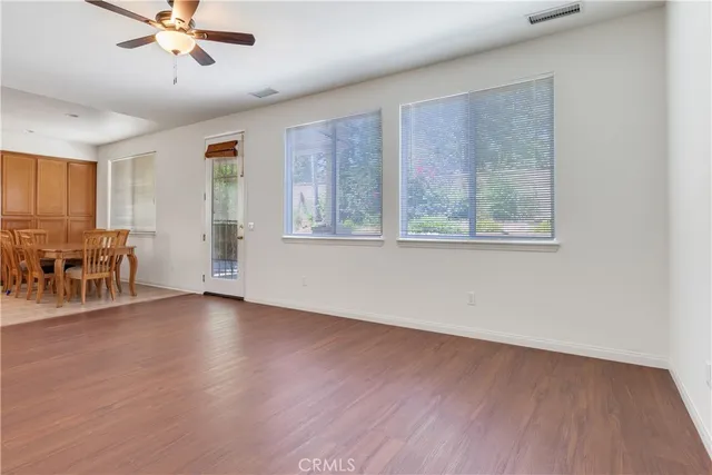 a view of a livingroom with furniture a ceiling fan and hardwood floor
