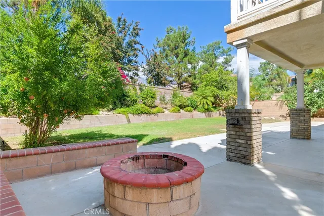 a patio with a table and chairs and plants