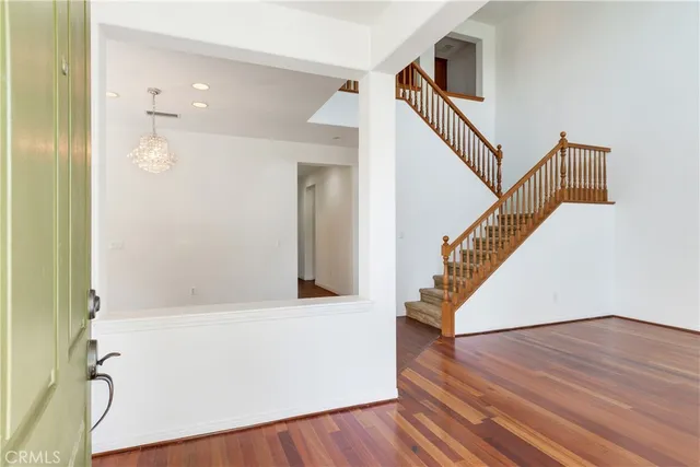 a view of a hallway with wooden floor and staircase