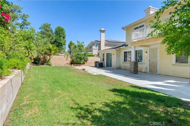 a front view of a house with a yard and potted plants