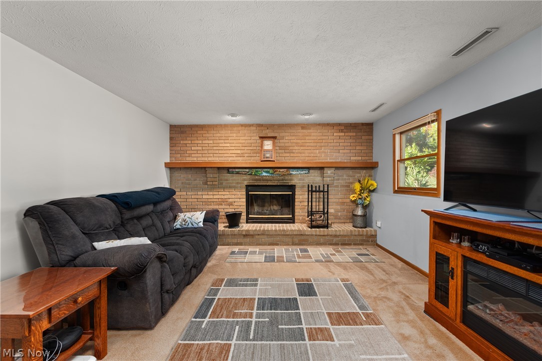 75 Houghton Road Northfield, OH 44067 - Photo 9 of 48 Brick fireplace with a wood-finish mantel and hearth