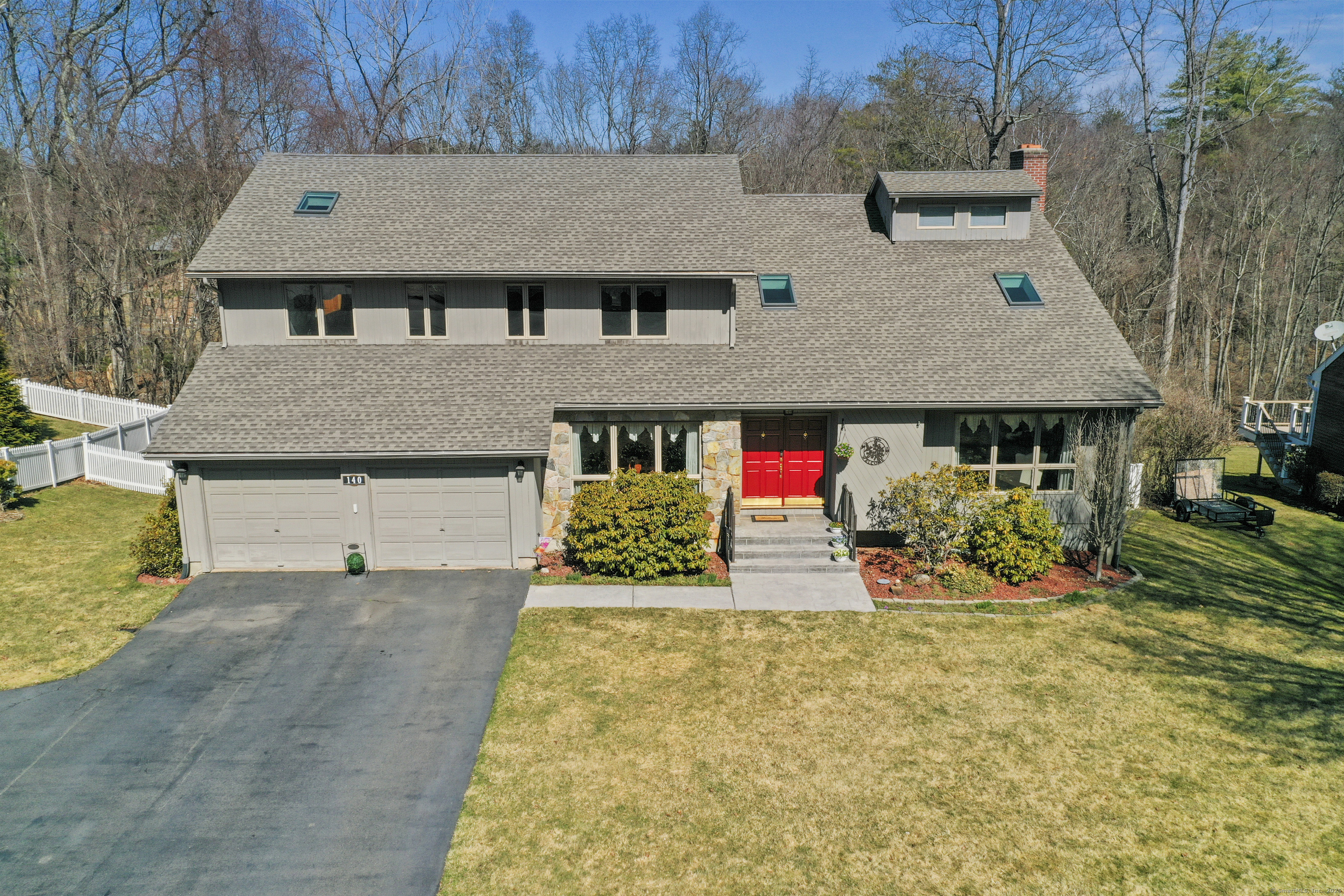a front view of a house with a yard and potted plants