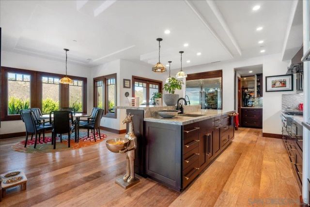 a view of a hallway with wooden floor and windows