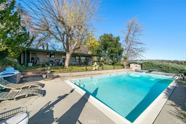 a view of a house with swimming pool and sitting area