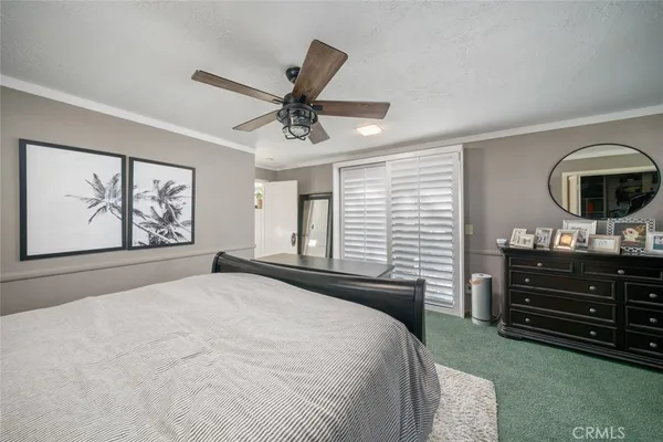 a bedroom with a large bed and a chandelier