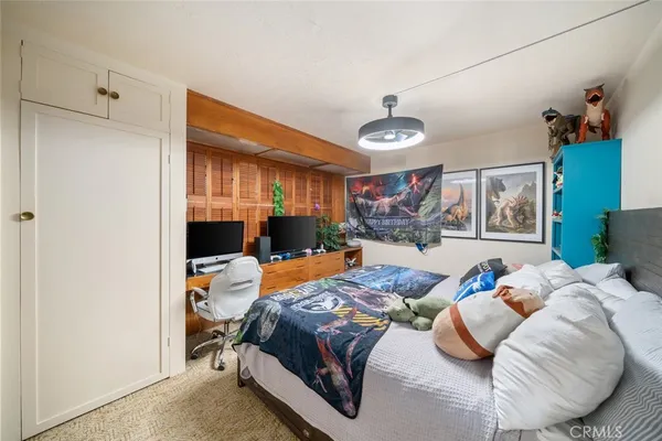 a bedroom with bed and a painting on the wall
