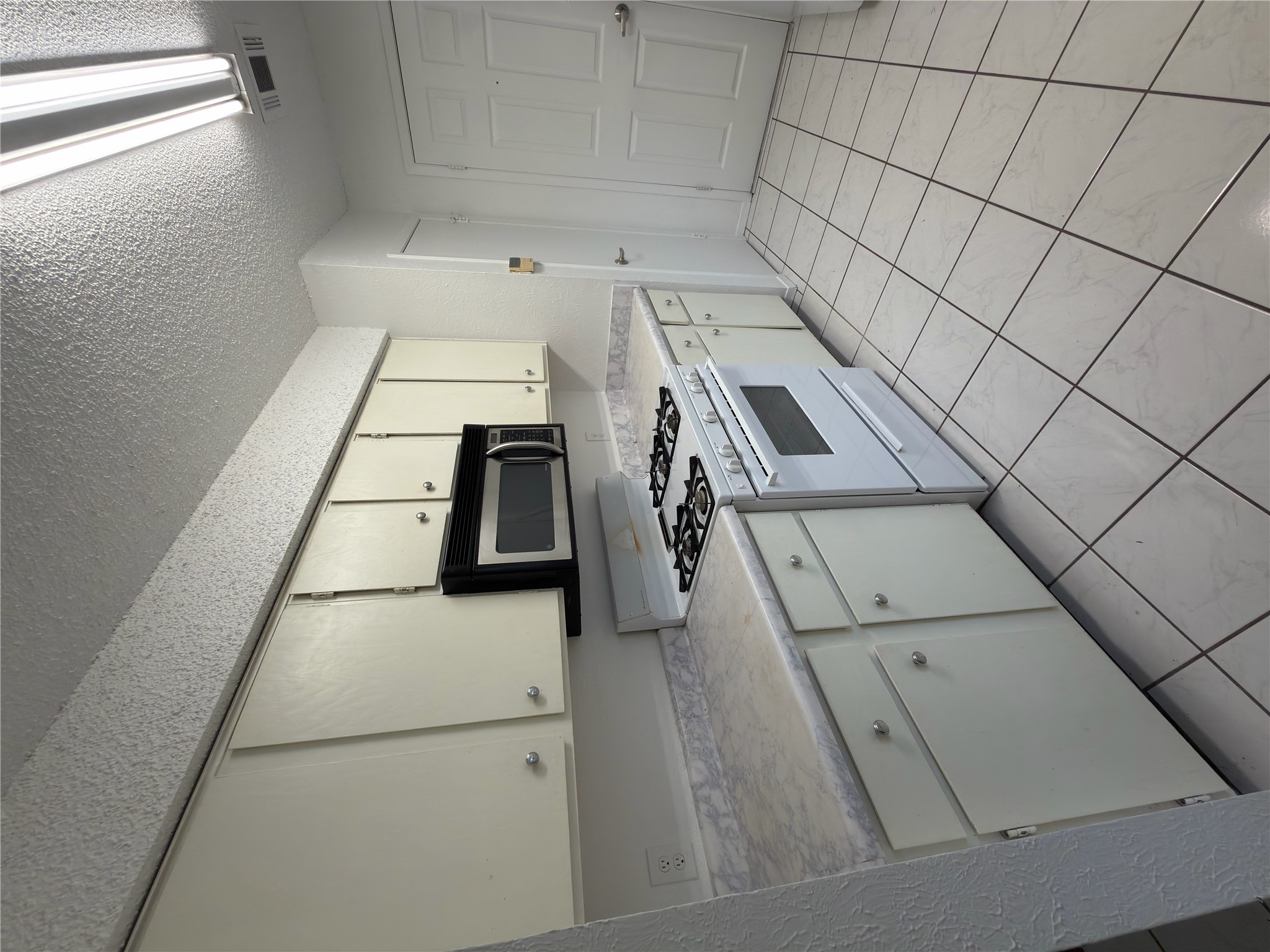 a kitchen with white cabinets a sink and a stove