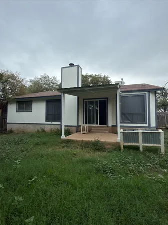 a backyard of a house with table and chairs