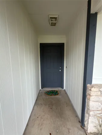 a view of a hallway with wooden walls