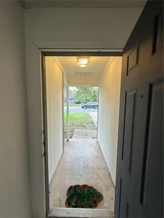 a view of a hallway with wooden floor and a porch