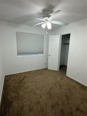 an empty room with a chandelier fan