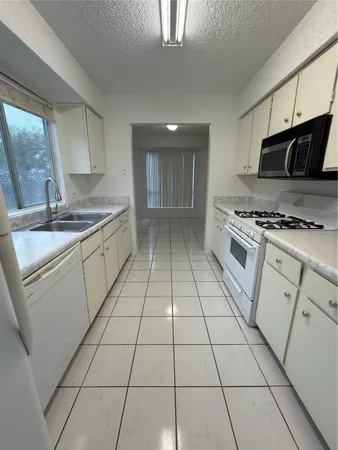 a kitchen with a stove a sink and a microwave