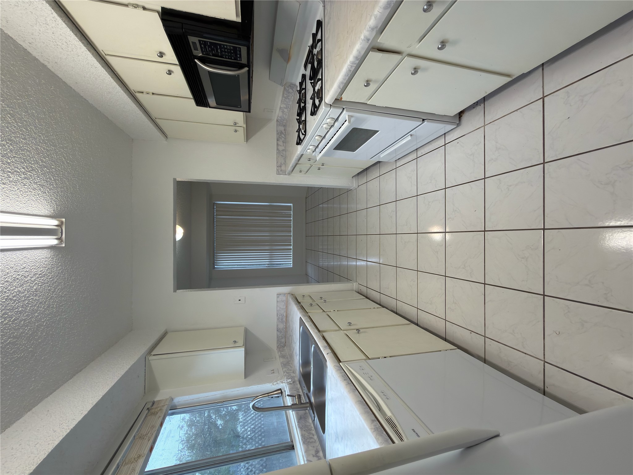 5601 Porsche Lane Austin, TX 78749 - Photo 6 of 38 a kitchen with a stove a sink and a microwave