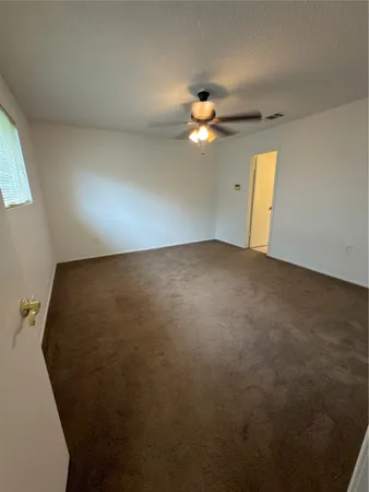 an empty room with a window and fireplace