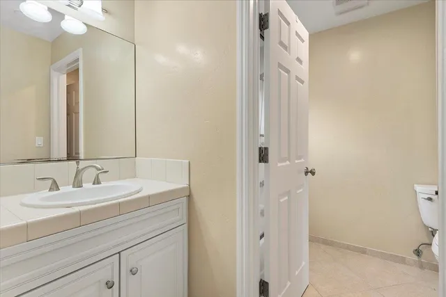 a bathroom with a sink a toilet and a mirror