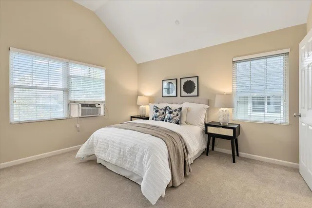 a bedroom with a bed lamp and a window