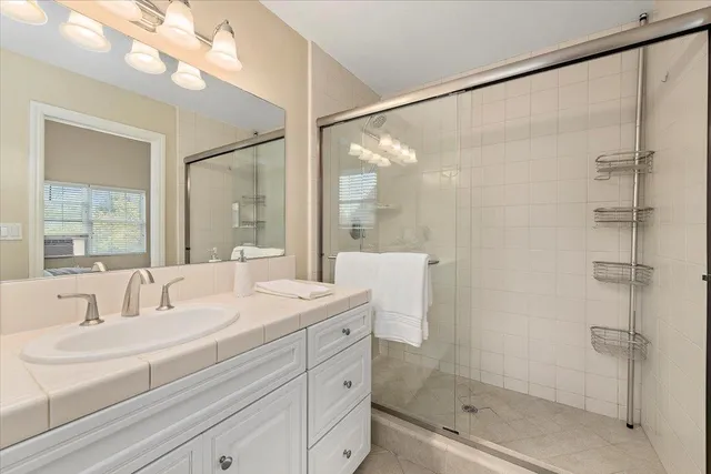 a bathroom with a double vanity sink mirror and shower